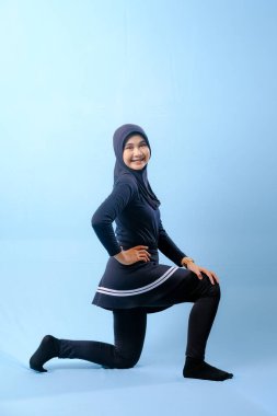 Beyaz çizgili siyah elbiseli bir kadın bir resim için poz veriyor. Siyah bir etek ve siyah pantolon giyiyor.