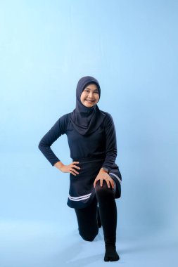 Beyaz çizgili siyah elbiseli bir kadın bir resim için poz veriyor. Siyah bir etek ve siyah pantolon giyiyor.