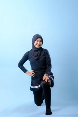 Beyaz çizgili siyah elbiseli bir kadın bir resim için poz veriyor. Siyah bir etek ve siyah pantolon giyiyor.