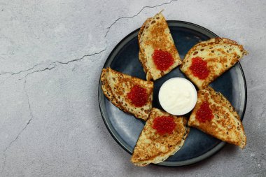 Havyarlı krep ve hafif arka planda bir tabakta ekşi krema. Üst manzara, düz uzanma