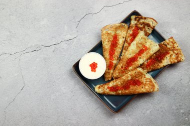 Havyarlı krep ve hafif arka planda bir tabakta ekşi krema. Üst manzara, düz uzanma