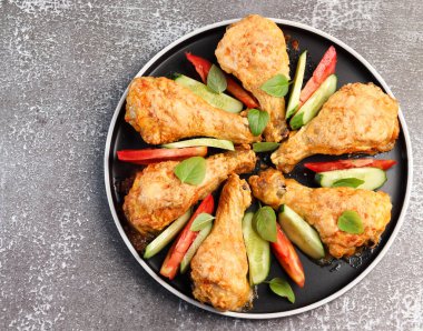 Siyah arka planda yuvarlak tabakta peynirli tavuk budu. Üst manzara, düz uzanma