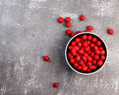 Koyu arkaplandaki bir kasede olgun dikenli meyveler. Üst manzara, düz uzanma