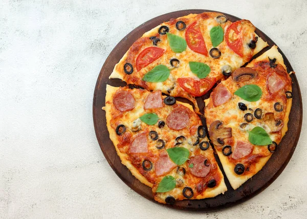Pizza Kiełbasą Szynką Oliwkami Grzybami Okrągłej Drewnianej Desce Krojenia Jasnoszarym — Zdjęcie stockowe