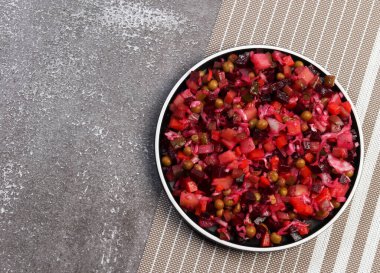 Geleneksel sirke salatası. Koyu arkaplanda yuvarlak bir tabakta pancar ve sebze salatası. Üst manzara, düz uzanma