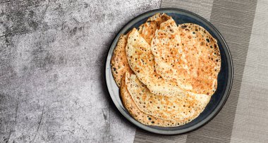 Geleneksel Rus maya ince krepler (krepler) koyu gri arka planda yuvarlak bir tabakta. Üst manzara, düz uzanma