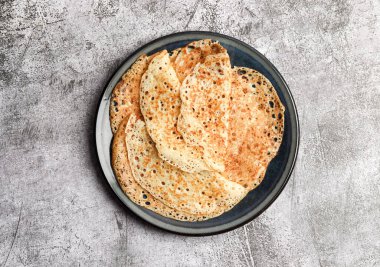 Geleneksel Rus maya ince krepler (krepler) koyu gri arka planda yuvarlak bir tabakta. Üst manzara, düz uzanma