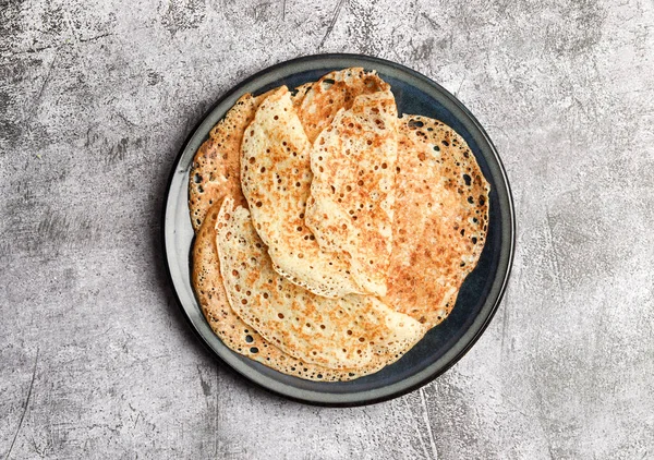 Geleneksel Rus maya ince krepler (krepler) koyu gri arka planda yuvarlak bir tabakta. Üst manzara, düz uzanma