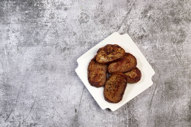 Beyaz kare bir tabakta koyu arkaplanda tuzlu yumurtalı ekmek. Üst manzara, düz uzanma