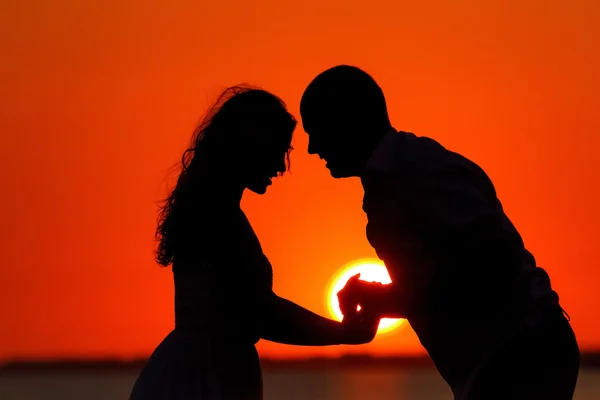 Romantik günbatımı ve aşıkların siluetleri