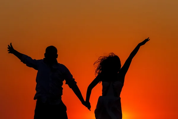 Romantik günbatımı ve aşıkların siluetleri