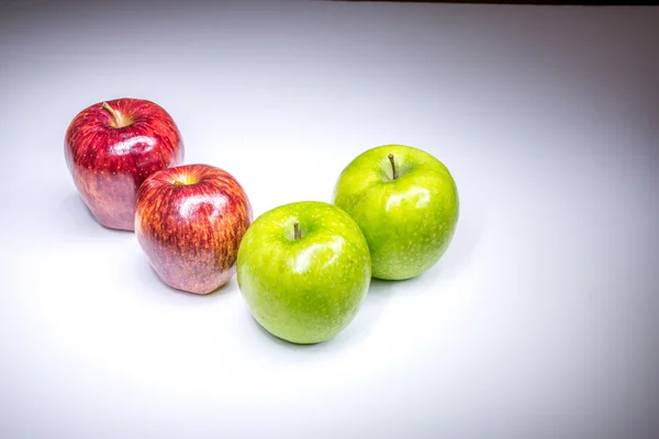 Fyra röda och gröna äpplen i fyra finger sammansättning målade med ljus — Stockfoto