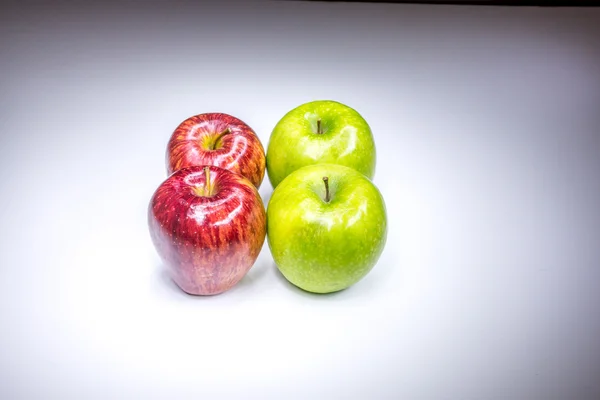 Four red and green apples in square composition painted with light — Stock Photo, Image