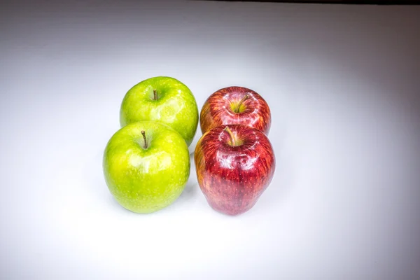 Four red and green apples in square composition painted with light — Stock Photo, Image