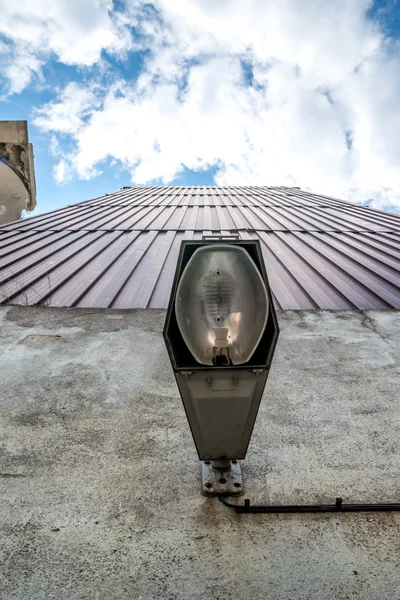 Vintage outdoor lamp with stolen bulb in abandoned factory sky view — Stock Photo, Image