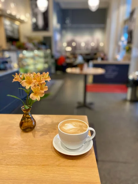 Kopi Latte Dalam Ruangan Kaffebrenneriet Atas Meja Kayu Dengan Bunga — Stok Foto