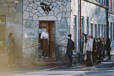 OSLO, NORway - 23 Ocak 2021: COVID-19 salgını sırasında Grunerlkka 'daki Tim Wendelboe kahve dükkanının önünde maske takan insanların kuyruğu