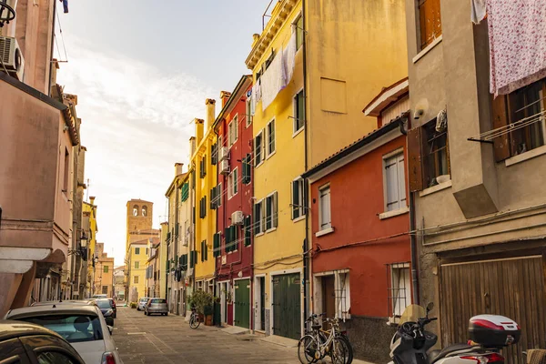 Romantic and characteristic Italian colorful street with multi colored houses in Chioggia near Venice, with sunset light — Stock Photo, Image