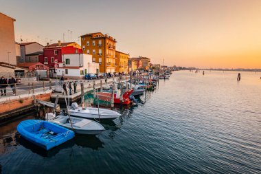 Venedik yakınlarındaki Ghioggia 'nın romantik şehirlerinde gün batımında kanallar, kanallar, köprüler ve kanallar var. Köprü di Vico