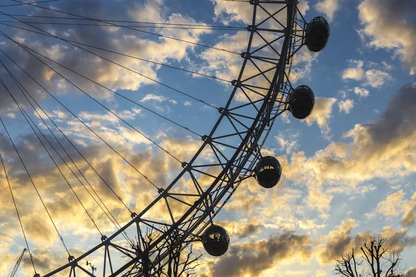 London, UK - 2016.04.05: London Eye with a Tree with yellow sunset and blue sky — Stock Photo, Image