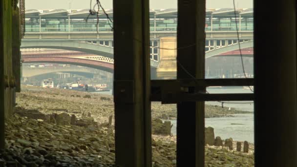 Нижний вид на мост с берега Темзы — стоковое видео