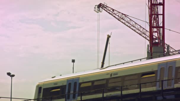 Tren pasando, grúa en el fondo — Vídeos de Stock