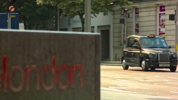 Лондон - 12 июня 2015 г.: Лондонский знак с черной кабиной и красным автобусом — стоковое видео