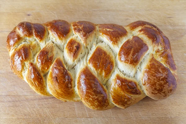 Pane di pane dolce intrecciato in tavola Immagine Stock