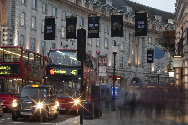 Лондон, Великобританія - 2014.May.28: червоний автобусів і чорний кабін на червоне світло на Ріджент-стріт у вечірній час. — стокове фото