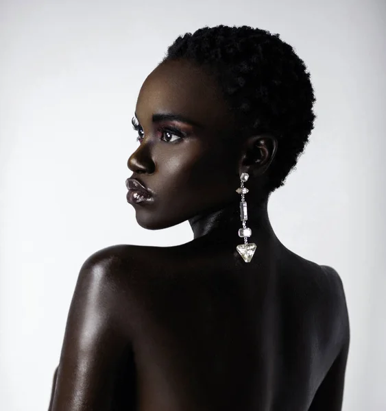 一个性感的年轻黑人女性的肖像 黑色短发 嘴唇沾满湿气 在明亮的背景面前戴着一只大钻石耳环 — 图库照片