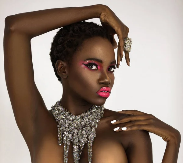 一个性感的年轻黑人女性的肖像 黑色的短发 粉色的唇膏 完美地修整指甲穿着大钻石项链在明亮的背景面前 — 图库照片