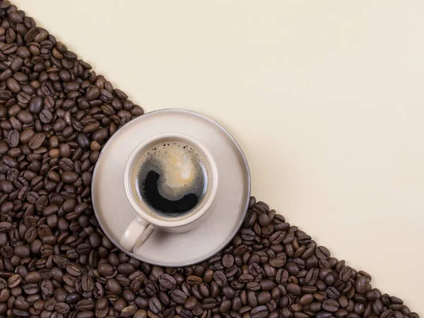 Kopp kaffe på bakgrunden med diagonal, kaffebönor och beige bakgrund. platt äggläggning — Stockfoto