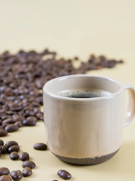 Een kop koffie op de achtergrond van koffiebonen. close-up — Stockfoto