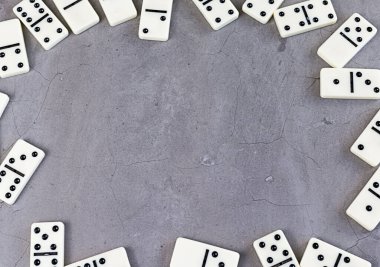 Gri arka planda beyaz domino taşları. Boşluğu kopyala