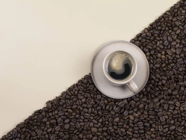 Kopp kaffe på bakgrunden med diagonal, kaffebönor och beige bakgrund. platt äggläggning — Stockfoto