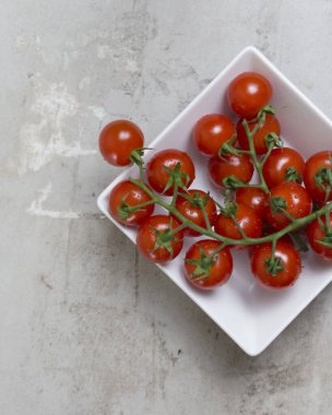 Beyaz kase içinde kırmızı küçük domatesler. Düz yatıyordu 