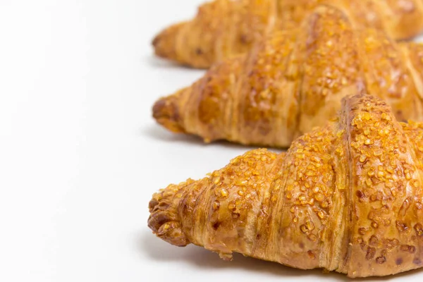 Tres croissants sabrosos sobre fondo blanco. Comida francesa. De cerca. — Foto de Stock