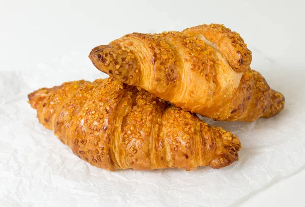 Dos croissants sabrosos sobre fondo blanco. Comida francesa. De cerca. — Foto de Stock