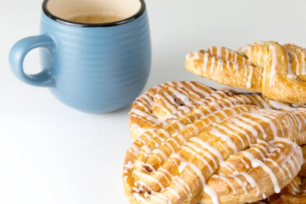 Rollo de canela o bollo de canela en el plato con taza de café azul. Panaderías clásicas americanas o francesas. — Foto de Stock