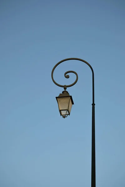 Viejo poste de luz en el fondo del cielo azul — Foto de Stock