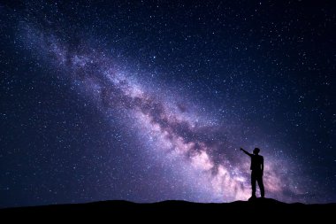 Gece manzarası ile Samanyolu ve bir adam silüeti