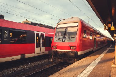 Güzel tren istasyonu ile modern kırmızı banliyö tren güneşler