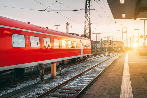 Güzel tren istasyonu ile modern kırmızı banliyö tren güneşler