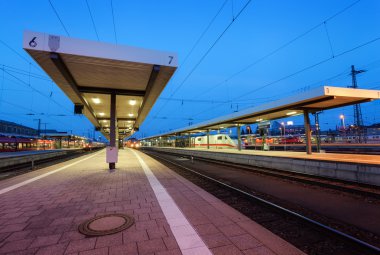 Güzel gece endüstriyel manzarası, modern tren istasyonu, Nuremberg, Almanya. Mavi gökyüzü arka plan üzerinde demiryolu platformu.