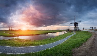 Renkli gündoğumu su yansıma su kanallarıyla yakınındaki güzel geleneksel Hollanda yel değirmenleri