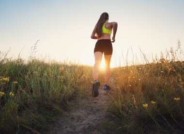 Gün batımında kırsal bir yolda kaçan genç sportif kız 