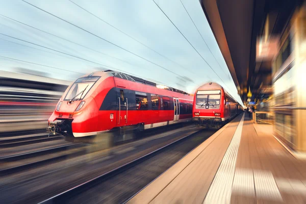 Gün batımında kırmızı modern yüksek hızlı yolcu treni. Demiryolu meydanının — Stok fotoğraf