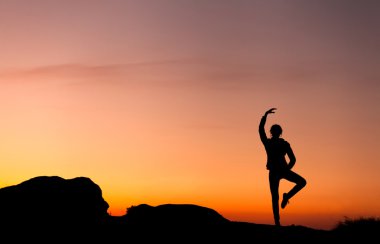 Güzel renkli gökyüzü karşı mutlu genç kadın silüeti. 