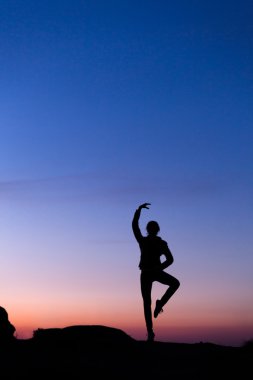 Güzel renkli gökyüzü karşı mutlu genç kadın silüeti. 