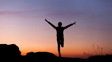 Güzel renkli gökyüzü karşı mutlu genç kadın silüeti. 